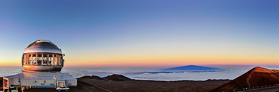 Maunakea’s highest point (far right) is tinged with light from the setting Sun, as shadows fall over Gemini North.[30]