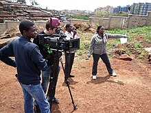 Filmmaker Nathan Collett (with camera) shooting feature film Togetherness Supreme in collaboration with Kibera youth trainees. TS-ONSET-small2.jpg