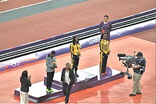 The women's 100-metre medalists at the 2012 Summer Olympics Womens 100 m medal ceremony - 2012 Olympics.jpg