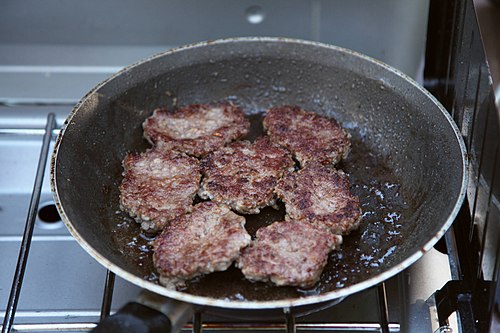Breakfast sausage patties, frying in a pan