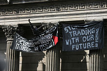 A protester hanging banners from the Bank of England G20 banners.jpg