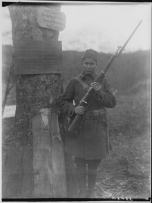 Miner, Cpl. George, a Winnebago from Tomah, Wisconsin, standing, with rifle, on guard duty, Niederahren, Germany, 01-02- - NARA - 530786.tif