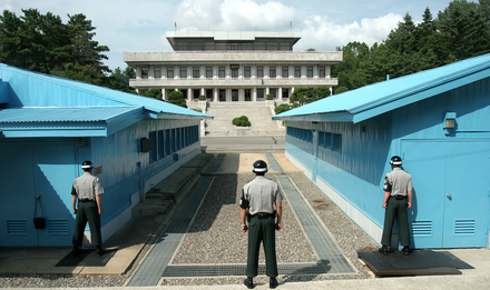 South Korean soldiers at the JSA (Joint Security Area) between the blue buildings, with North Korea in the background