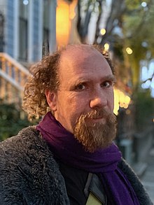 Photographic portrait of Peter Eckersley on a San Francisco Street at twilight