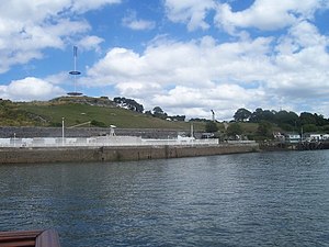 Mount Wise with 1770s Redoubt now containing a 40 m high mast erected in 1998 with circular viewing platform for recreational visitors, and statue of Winged Victory atop the Scott Memorial (distant right), commemorating the explorer Captain Robert Falcon Scott, Royal Navy, and others who died in March 1912 on their return from the South Pole. Behind the low white wall in the foreground is a series of small swimming pools Plymouth , Coastline - geograph.org.uk - 1146754.jpg