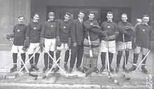 Fotografía en blanco y negro de un equipo de hockey sobre hielo posando con sus uniformes.