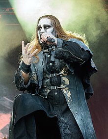 Zpěvák Attila Dorn na koncertu v roce 2016. Zpívá do mikrofonu a gestikuluje pravou rukou.