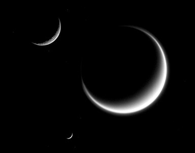 Titan (largest) together with Rhea and Mimas (smallest) in crescent shape, forming a triple crescent.[228] Titan's massive atmosphere is clearly seen extending out into space, while Rhea and Mimas have none.