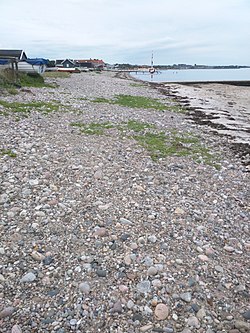 Stranden på Råå, med sten och där havet skymtas.