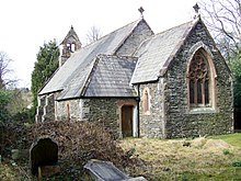 Eine kleine Steinkirche von Südosten aus gesehen mit einem kurzen Chor, einer Veranda im Südosten, einem gestützten Kirchenschiff und einer Westglocke