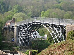 The application of the steam engine allowed coke to be substituted for charcoal in iron making, lowering the cost of iron, which provided engineers with a new material for building bridges. This bridge was made of cast iron, which was soon displaced by less brittle wrought iron as a structural material. The world's first iron bridge.jpg