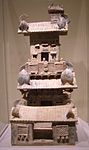 Una torre de cerámica con un patio inferior, ménsulas de soporte dougong, grandes tejas curvas de alero y figuras humanas
