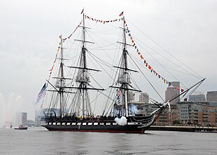 USS Constitution, dressed overall, fires a seventeen-gun salute in Boston Harbor, 4 July 2014. USS Constitution fires a 17-gun salute.jpg