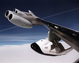 Le X-38, accroché au pylône d'emport, est visible grâce au hublot percé dans le fuselage.