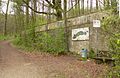 Stützmauer am Hang mit verwittertem Logo der Gilde Brauerei