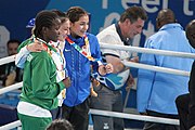 Deutsch: Boxen bei den Olympischen Jugendspielen 2018 Tag 12, 18. Oktober 2018 - Medaillenzeremonie im Fliegengewicht der Mädchen - Gold: Martina La Piana (Italien), Silber: Adijat Gbadamosi (Nigeria), Bronze: Heaven Destiny Garcia (USA); Medaillenübergabe durch Habu Gumel (IOC, Nigeria), Geschenkübergabe durch Dr. Joseph O. Ayeni (Nigeria, AIBA). English: Boxing at the 2018 Summer Youth Olympics on 18 October 2018 – Girl's flyweight Medal Ceremony - Gold: Martina La Piana (Italy), Silver: Adijat Gbadamosi (Nigeria), Bronze: Heaven Destiny Garcia (USA); Medal handover by Habu Gumel (IOC, Nigeria), Gift presented by Dr. Joseph O. Ayeni (Nigeria, AIBA). Español: Boxeo en los Juegos Olímpicos Juveniles de Verano de 2018 en 18 de octubre de 2018 - Ceremonia de la Medalla de peso mosca para niñas - Oro: Martina La Piana (Italia), Plata: Adijat Gbadamosi (Nigeria), Bronce: Heaven Destiny Garcia (Estados Unidos); Entrega de medallas por Habu Gumel (COI, Nigeria), Regalo presentado por Joseph O. Ayeni (Nigeria, AIBA).