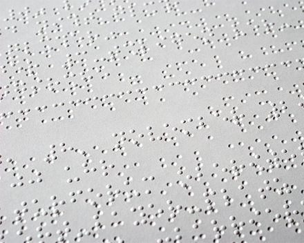 Image of a page showing both the raised braille characters, and the recessed characters on the other side of the page.