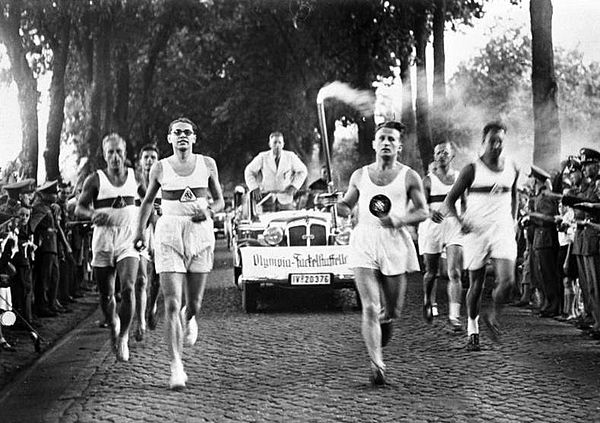 Runners carrying the Olympic Flame