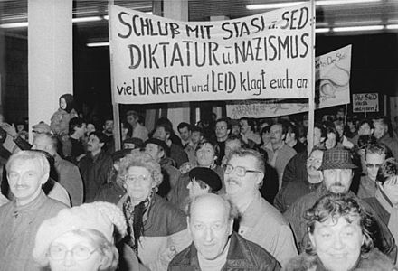 Kansalaisia protestoimassa Stasia vastaan 16. tammikuuta 1990. Kyltissä väitetään Stasin sekä Saksan sosialistisen yhtenäisyyspuolueen olevan natsienkaltaisia diktaattoreja.