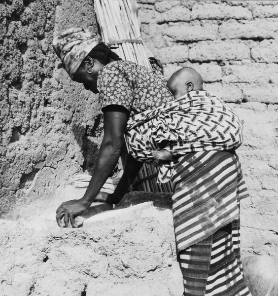File:COLLECTIE TROPENMUSEUM Een Samo vrouw met kind op de rug maalt het graan tussen twee stenen TMnr 20010226.jpg