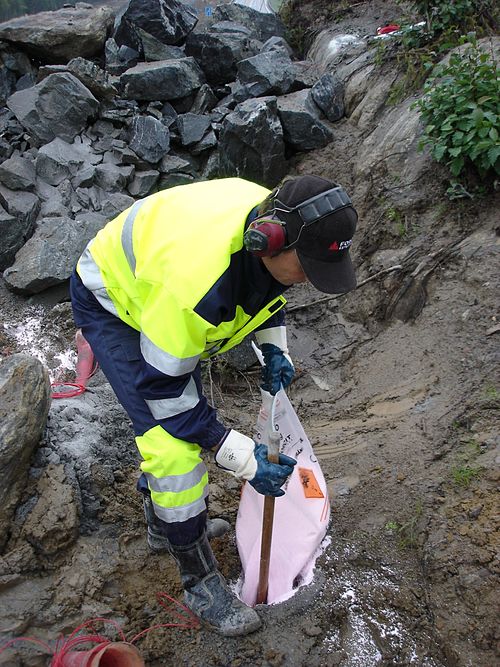 Charging a hole with ANFO for rock blasting