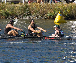 A coxswain (far right) sitting in the stern of the boat, facing the rowers, at the Head of the Charles Regatta. Coxswain HOC 1.jpg