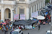 Protestors in mid-January 2020 occupying the area outside the Old Townhouse across the road from the Central Methodist Church which was occupied inside and outside by the protestors following their October 2019 eviction from the Waldorf Arcade. Greenmarket Refugee sitin 14 Jan 2020.jpg