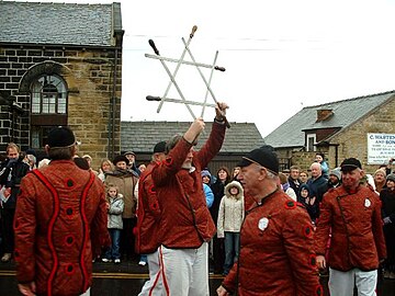 Le capitaine de la troupe du Grenoside brandit un faisceau d’épées avant de le passer autour de son cou (fêtes de noël de 2005).