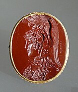 A red gemstone with a helmeted woman's face in profile