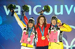 Amy Williams of Great Britain (centre) with the gold medal she won in the women's skeleton alongside silver medalist Kerstin Szymkowiak (left) and bronze medalist Anja Huber (right). Kerstin Szymkowiak Amy Williams and Anja Huber2.jpg