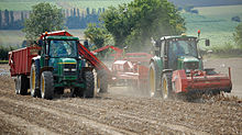 A tractor with a front-mounted haulm topper and a trailed potato harvester Lifting potatoes near Bonby, 2011.jpg