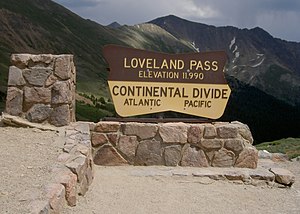 The Loveland Pass sign, with the mountain's peak visible behind it at center