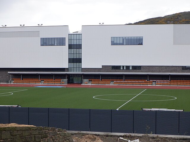 Redeveloped Meadowbank's pitch, track and small stand in front of indoor sport facility (2023)