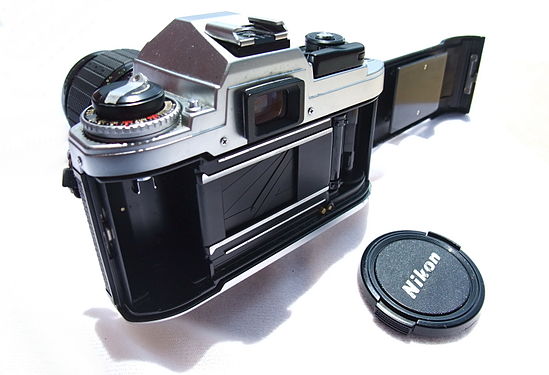 A Nikon FG camera with the back opened and showing the film chamber