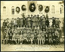 Photo de groupe telle une photo de classe en noir et blanc et surmontée de trois portraits.