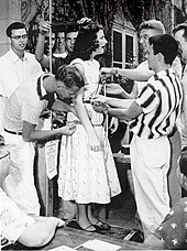 An anguished female student endures the weigh-in, 1953 Pomona College weigh-in.jpg