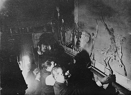 Stagehands moving zinc figures behind the screen of the Théatre d'Ombres in Le Chat Noir