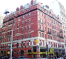 Photo couleurs de l'angle d'un immeuble de six étages en brique rouge dans les rues de New York