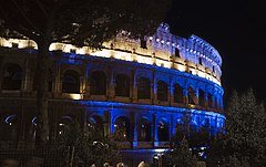 The Colosseum at night, lit in colored lights, Rome, Italy