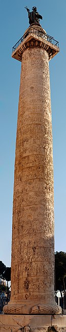 hohe weiße Säule, gerade und mit einer Spirale verziert, überragt von einer kleinen quadratischen Plattform, auf der eine Statue eines Mannes ruht.