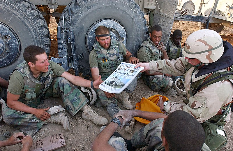 File:US Navy 030404-M-0000D-001 Command Sgt. Maj. John Sparks, delivers copies of Stars and Stripes to U.S. Marines from Weapons Platoon, 3-2 India Company.jpg