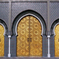 Modern use of traditional Moroccan decor at the gates of the Royal Palace in Fes, displaying delicate metalwork and ceramic art.