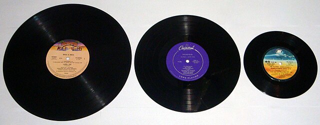 Three vinyl records of different formats, from left to right: a 12 inch LP, a 10 inch LP, a 7 inch single