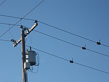 Three powerline sensors hanging on conductors 2 meters to the right of a power pole with a distribution transformer and communication network node WirelessPowerlineSensors2.jpg