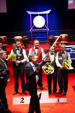 2013 Award ceremony.
Ludo Dielis hands over the diamant-cue to the winner Frederic Caudron.
From Left to right: Vice world champion Filippos Kasidokostas, Caudron, Bronze medal winners Alexander Salazar and Dick Jaspers. 2013 3-cushion World Championship-Day 5-Award ceremony-47 (XS).jpg