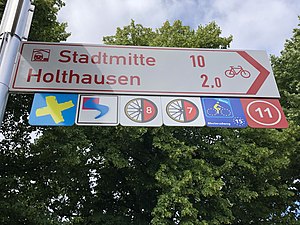 guidepost finger with destinations and route symbols.