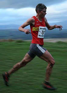 Angela Mudge, competing at the 2007 "Whangie Whizz" race in Scotland, when she set a course record for women. She is wearing her usual colours, a red shirt with yellow horizontal band, representing Carnethy Running Club. Angela mudge whangie2007.jpg