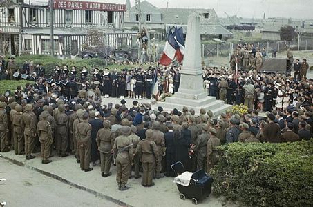 Die offizielle Zeremonie am Denkmal für die Toten in Courseulles-sur-Mer am 14. Juli 1944, dem Nationalfeiertag, in Anwesenheit der lokalen Bevölkerung und Soldaten der französischen Befreiungsarmee und alliierter Einheiten.