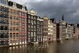 Colorful canal houses at golden hour in Damrak avenue Amsterdam the Netherlands