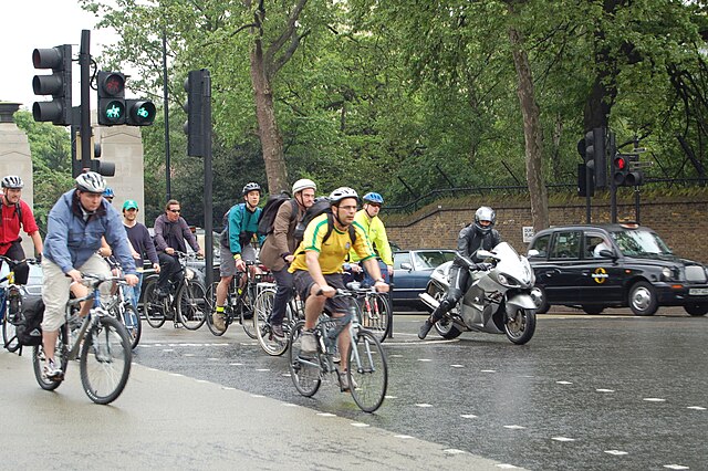 Cyclists use a segregated cut through of a busy interchange in London at rush hour.